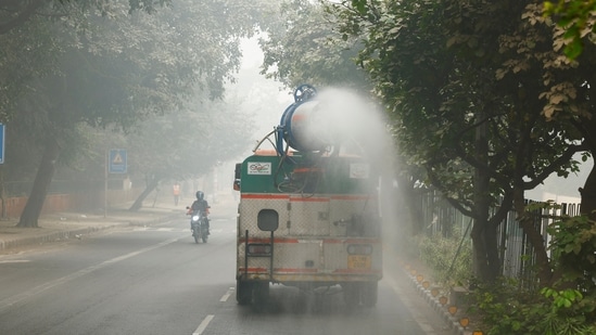 Delhi AQI live updates:  A vehicle sprays water to curb dust and pollution as the sky is enveloped with smog after Delhi's air quality turned "hazardous" in New Delhi. (REUTERS)