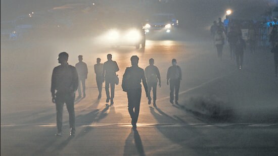 People walk through dense smog at Kartavya Path on Tuesday evening. (RAJ K RAJ /HT PHOTO)