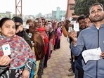 Voters show their IDs while waiting in queues to cast their vote for the second and final phase of the Jharkhand assembly election.