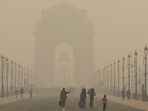 Women walk on a road near India Gate as the sky is enveloped with smog after Delhi's air quality worsened due to air pollution, in New Delhi, India, on Tuesday. Women walk on a road near India Gate as the sky is enveloped with smog after Delhi's air quality worsened due to air pollution, in New Delhi, India, on Tuesday.