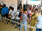 Voters stand in queues to cast their ballots to vote at a polling booth, during the Maharashtra state assembly elections in Mumbai on November 20, 2024. 