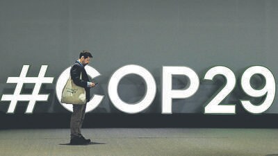 A man stands next to the logo of the COP29 United Nations climate change conference, in Baku, Azerbaijan, on Wednesday. (REUTERS) A man stands next to the logo of the COP29 United Nations climate change conference, in Baku, Azerbaijan, on Wednesday. (REUTERS)