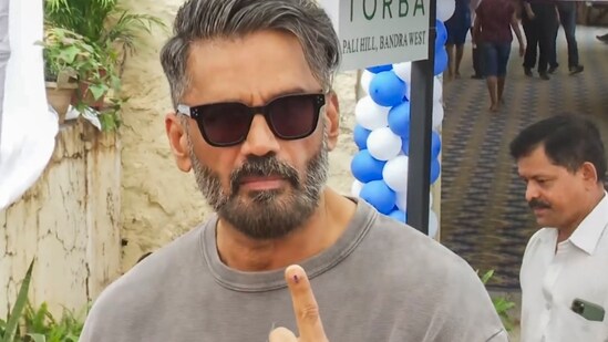 Actor Suniel Shetty shows his ink-marked finger after casting vote during the Maharashtra Assembly elections.(PTI)