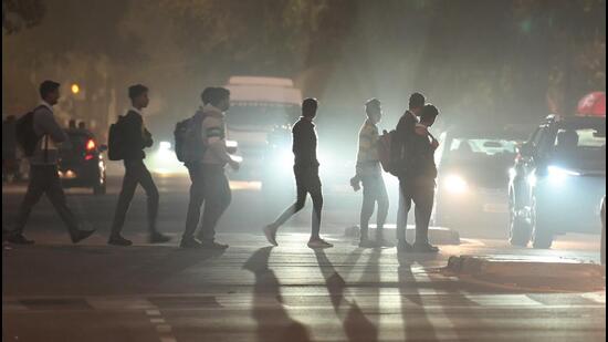 Workers returning home in the evening, amid smoggy conditions. (RAJ K RAJ /HT PHOTO)