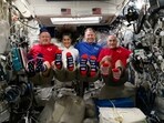 In this photo provided by NASA, from left, astronauts Butch Wilmore, Suni Williams, Nick Hague and Don Pettit show their U.S. flag-themed socks aboard the International Space Station on Election Day, Tuesday, Nov. 5, 2024. 