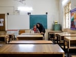 School teachers conduct online classes using a mobile phone in an empty classroom after schools were ordered shut by the Delhi government as Delhi's air quality worsened. REUTERS