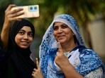 First time voter Azmathunnisa Laheri along with her mother Iffathunnisa Laheri gets selfie after casting their vote for State assembly elections at voting centre in Dongri, in Mumbai, India, on Wednesday, November 20, 2024.  (Photo by Anshuman Poyrekar/ Hindustan Times)