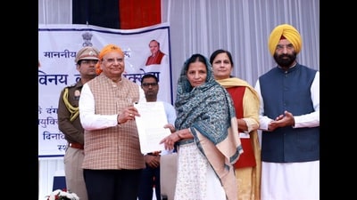 Delhi lieutenant governor VK Saxena presenting a job letter to a survivor of the 1984 anti-Sikh riots at an event held in Tilak Vihar on Thursday. (HT File)