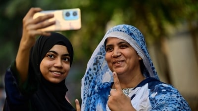 First time voter Azmathunnisa Laheri along with her mother Iffathunnisa Laheri gets selfie after casting their vote for State assembly elections at voting centre in Dongri, in Mumbai, India, on Wednesday, November 20, 2024.  (Photo by Anshuman Poyrekar/ Hindustan Times) (Hindustan Times)