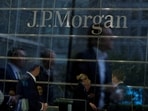 Workers are reflected in the windows of the Canary Wharf offices of JP Morgan in London
