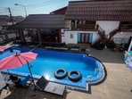 A foreign tourist rests near a swimming pool at Nana Backpackers hostel in Vang Vieng.