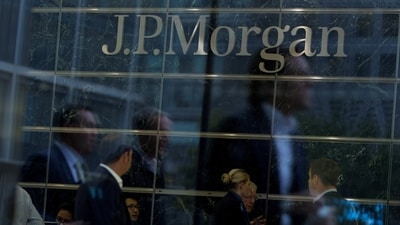 Workers are reflected in the windows of the Canary Wharf offices of JP Morgan in London (Reuters)