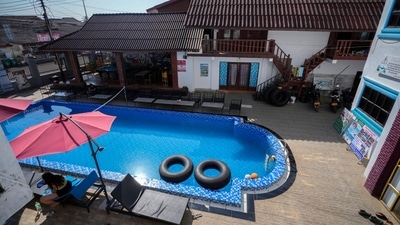 A foreign tourist rests near a swimming pool at Nana Backpackers hostel in Vang Vieng. (AP) A foreign tourist rests near a swimming pool at Nana Backpackers hostel in Vang Vieng. (AP)
