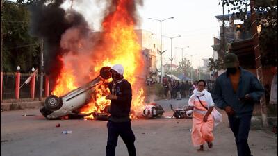 People escape as smoke and flames billow from vehicles that were set on fire during demonstrations after three bodies of missing persons from Jiribam were found near the Manipur-Assam border last week. (PTI Photo) People escape as smoke and flames billow from vehicles that were set on fire during demonstrations after three bodies of missing persons from Jiribam were found near the Manipur-Assam border last week. (PTI Photo)