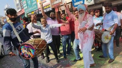 Aam Aadmi Party workers celebrating the victory of their candidates in three of the four assembly byelections in Punjab on Saturday. (Sanjeev Kumar/HT)