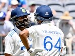 India's Virat Kohli (L) talks to teammate Yashasvi Jaiswal on day three of the first Test cricket match between Australia and India.