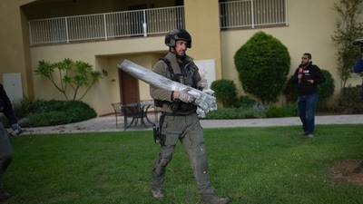 An Israeli bomb squad policeman carries the remains of a rocket that was fired from Lebanon in Kibbutz Kfar Blum, northern Israel Sunday Nov. 24, 2024. (AP) An Israeli bomb squad policeman carries the remains of a rocket that was fired from Lebanon in Kibbutz Kfar Blum, northern Israel Sunday Nov. 24, 2024. (AP)