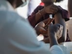 A Nigerian health official prepares to administer a mpox vaccination to a woman