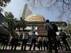 People look at a screen displaying the Sensex results on the facade of the Bombay Stock Exchange (BSE) building in Mumbai.