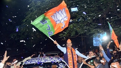 Maharashtra deputy chief minister and BJP candidate Devendra Fadnavis waves the party's flag as he arrives to collect his winning certificate from the Nagpur South West Constituency in Nagpur on Saturday. (ANI) (HT_PRINT) Maharashtra deputy chief minister and BJP candidate Devendra Fadnavis waves the party's flag as he arrives to collect his winning certificate from the Nagpur South West Constituency in Nagpur on Saturday. (ANI) (HT_PRINT)
