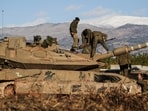 Israeli soldiers work on a tank, amid cross-border hostilities between Hezbollah and Israel, by Israel's border with Lebanon in northern Israel, November 26, 2024.
