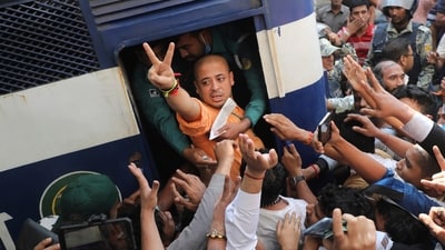 Bangladeshi Hindu leader Krishna Das Prabhu shows a victory sign as he is taken in a police van after the court ordered him detained pending further proceedings in Chattogram on November 26, (AP) Bangladeshi Hindu leader Krishna Das Prabhu shows a victory sign as he is taken in a police van after the court ordered him detained pending further proceedings in Chattogram on November 26, (AP)