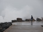 A man walks past high tides lashing at Marina Beach as Tamil Nadu braces for Cyclone Fengal