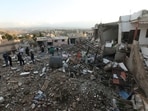 People gather at a damaged site in Tayr Debba, on the second day of the ceasefire between Israel and Iran-backed group Hezbollah.