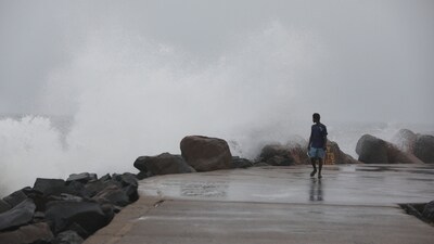 A man walks past high tides lashing at Marina Beach as Tamil Nadu braces for Cyclone Fengal (Lakshmi )