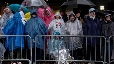 People stand in the rain along Sixth Avenue ahead of the start of the Macy's Thanksgiving Day Parade. (AP) People stand in the rain along Sixth Avenue ahead of the start of the Macy's Thanksgiving Day Parade. (AP)