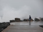 A man walks past high tides lashing at Marina Beach as Tamil Nadu braces for Cyclone Fengal, in Chennai. 