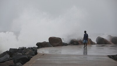 A man walks past high tides lashing at Marina Beach as Tamil Nadu braces for Cyclone Fengal, in Chennai. (ANI) A man walks past high tides lashing at Marina Beach as Tamil Nadu braces for Cyclone Fengal, in Chennai. (ANI)