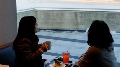 Customers look at North Korea's propaganda village in the new Starbucks at the top of the Aegibong Peak Observatory, south of the demilitarized zone (DMZ), in South Korea. (Reuters)