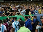 Players of Argentina try to calm the crowd after a fight between Brazilian and Argentinian fans. (AP Photo/Silvia Izquierdo) Players of Argentina try to calm the crowd after a fight between Brazilian and Argentinian fans. (AP Photo/Silvia Izquierdo)