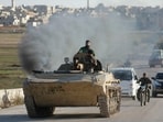 Anti-government fighters drive down a road in Maaret al-Numan in Syria's northwestern Idlib province on November 30, 2024.
