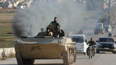 Anti-government fighters drive down a road in Maaret al-Numan in Syria's northwestern Idlib province on November 30, 2024. (AFP) Anti-government fighters drive down a road in Maaret al-Numan in Syria's northwestern Idlib province on November 30, 2024. (AFP)