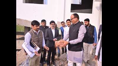 Dy CM Brajesh Pathak checking the quality of bricks at Chandauli trauma centre on Saturday (Twitter)