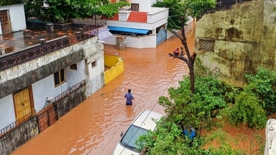 A commuter wades through a flooded street in the aftermath of Cyclone Fengal, in Puducherry (PTI) A commuter wades through a flooded street in the aftermath of Cyclone Fengal, in Puducherry (PTI)