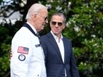 President Joe Biden, wearing a Team USA jacket and walking with his son Hunter Biden, heads toward Marine One on the South Lawn of the White House in Washington, July 26, 2024. 