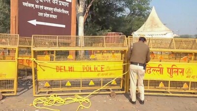 Farmers' march: A policeman puts up barricades at Chilla border after security was heightened in view of farmers' protest march towards Delhi. Farmers' march: A policeman puts up barricades at Chilla border after security was heightened in view of farmers' protest march towards Delhi.