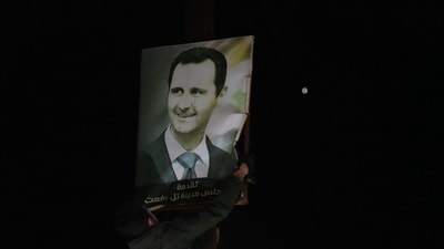 Anti-government fighters tore up posters of President Bashar al Assad a atfter taking over the northern Syrian town of Tal Rifaat. The president has reportedly fled to ally Russia. (AFP) Anti-government fighters tore up posters of President Bashar al Assad a atfter taking over the northern Syrian town of Tal Rifaat. The president has reportedly fled to ally Russia. (AFP)