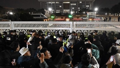 People gather in front of the main gate of the National Assembly in Seoul, South Korea. (AFP)