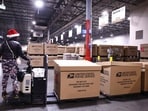 LOS ANGELES, CALIFORNIA - DECEMBER 03: A U.S. Postal Service employee transports parcels for distribution during the start of the holiday mail rush, following Black Friday and Cyber Monday, inside the Los Angeles Mail Processing & Distribution Center on December 3, 2024 in Los Angeles, California.   Mario Tama/Getty Images/AFP (Photo by MARIO TAMA / GETTY IMAGES NORTH AMERICA / Getty Images via AFP)