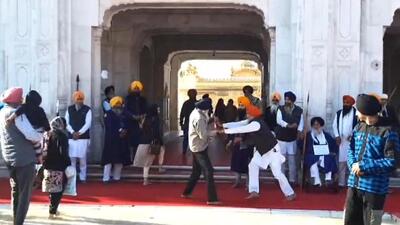 A Punjab Police officer fends off the shooter, Narain Singh Chaura, who opened fire at Sukhbir Singh Badal (seated) at the Golden Temple complex on Wednesday morning. (ANI) A Punjab Police officer fends off the shooter, Narain Singh Chaura, who opened fire at Sukhbir Singh Badal (seated) at the Golden Temple complex on Wednesday morning. (ANI)