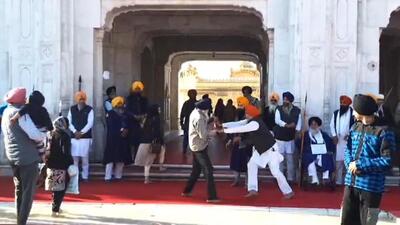 A Punjab Police officer fends off the shooter, Narain Singh Chaura, who opened fire at Sukhbir Singh Badal (seated) at the Golden Temple complex on Wednesday morning. (HT ) A Punjab Police officer fends off the shooter, Narain Singh Chaura, who opened fire at Sukhbir Singh Badal (seated) at the Golden Temple complex on Wednesday morning. (HT )