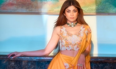 OUTFIT: NEHHA NHATA
JEWELLERY: VIRRAYAA JEWELLERY
Perfect for daytime festivities, Shilpa looks ethereal in a draped yellow lehenga set by Nehha Nhata. It features a fuss-free draped pallu paired with a hand- embroidered blouse and an organza lehenga. She completes the look with a polki and diamond choker by Virrayaa Jewellery. OUTFIT: NEHHA NHATA
JEWELLERY: VIRRAYAA JEWELLERY
Perfect for daytime festivities, Shilpa looks ethereal in a draped yellow lehenga set by Nehha Nhata. It features a fuss-free draped pallu paired with a hand- embroidered blouse and an organza lehenga. She completes the look with a polki and diamond choker by Virrayaa Jewellery.