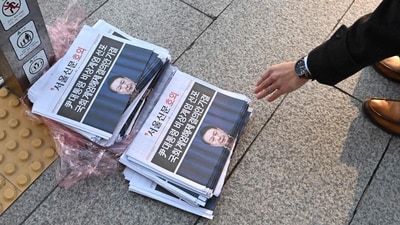 A man picks up an extra edition newspaper displayed at a subway gate in downtown Seoul (AFP) A man picks up an extra edition newspaper displayed at a subway gate in downtown Seoul (AFP)