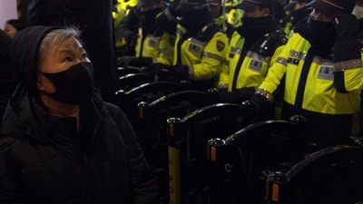 A woman looks up near a police barricade with rows of police officers blocking a protest march to the presidential office after a candlelight vigil against South Korean President Yoon Suk Yeol, in Seoul, South Korea, Wednesday, Dec. 4, 2024 (AP Photo/Ng Han Guan) (AP) A woman looks up near a police barricade with rows of police officers blocking a protest march to the presidential office after a candlelight vigil against South Korean President Yoon Suk Yeol, in Seoul, South Korea, Wednesday, Dec. 4, 2024 (AP Photo/Ng Han Guan) (AP)