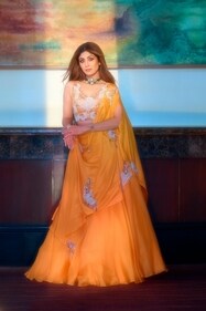 OUTFIT: NEHHA NHATA
JEWELLERY: VIRRAYAA JEWELLERY
Perfect for daytime festivities, Shilpa looks ethereal in a draped yellow lehenga set by Nehha Nhata. It features a fuss-free draped pallu paired with a hand- embroidered blouse and an organza lehenga. She completes the look with a polki and diamond choker by Virrayaa Jewellery. OUTFIT: NEHHA NHATA
JEWELLERY: VIRRAYAA JEWELLERY
Perfect for daytime festivities, Shilpa looks ethereal in a draped yellow lehenga set by Nehha Nhata. It features a fuss-free draped pallu paired with a hand- embroidered blouse and an organza lehenga. She completes the look with a polki and diamond choker by Virrayaa Jewellery.