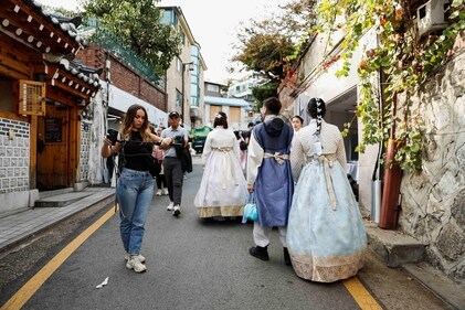 Tourists, including some dressed in traditional Korean hanbok, walk through Bukchon Hanok Village in Seoul, South Korea. (Photo by REUTERS/Kim Soo-hyeon)
